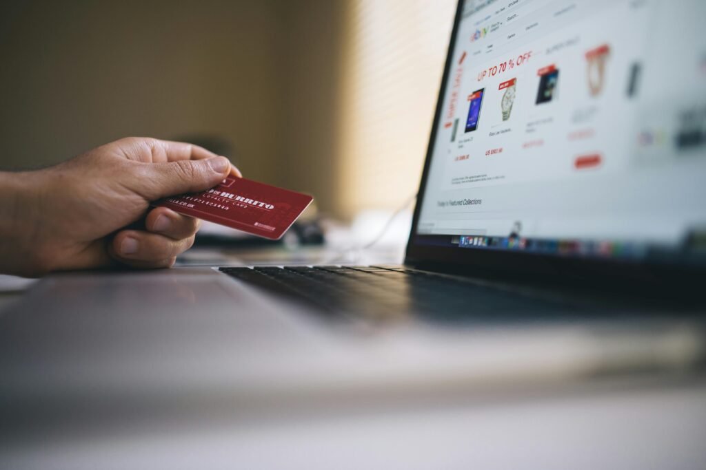 pexels photo 34577 Person holding a credit card while shopping online on a laptop, indicating ecommerce transactions.